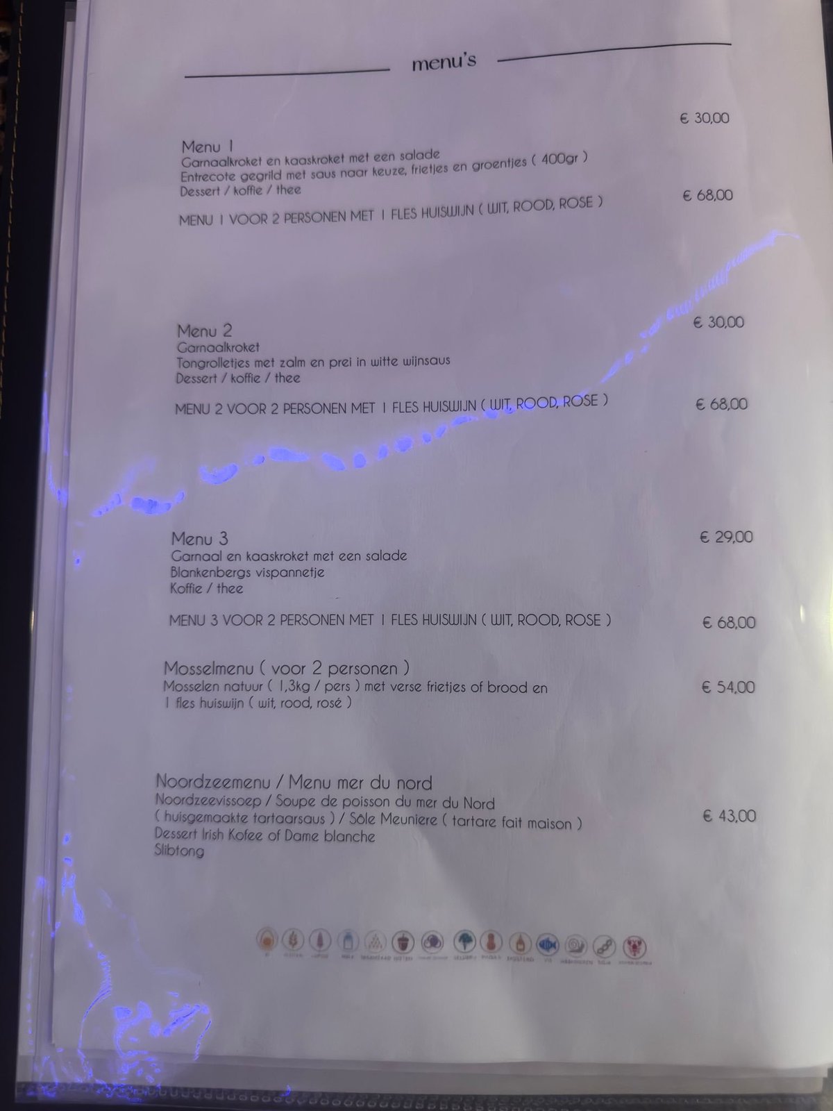 Restaurant menu page with Dutch text listing three menu options and prices in euros, with blue neon light reflections